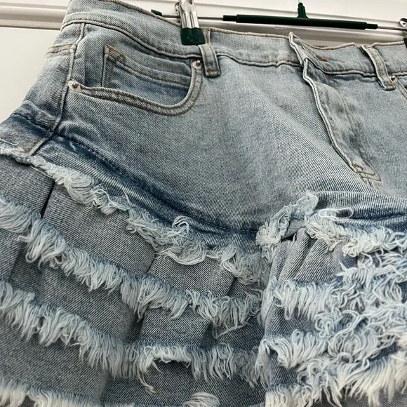 Work it Ms. thang in your booty-licious distressed ruffled denim shorts