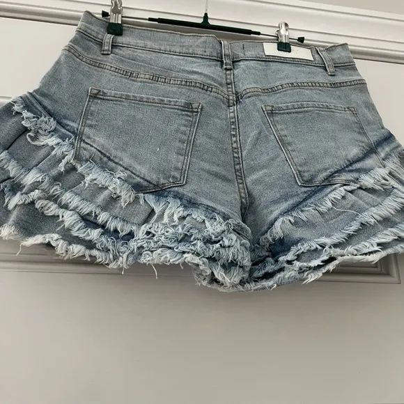 Work it Ms. thang in your booty-licious distressed ruffled denim shorts